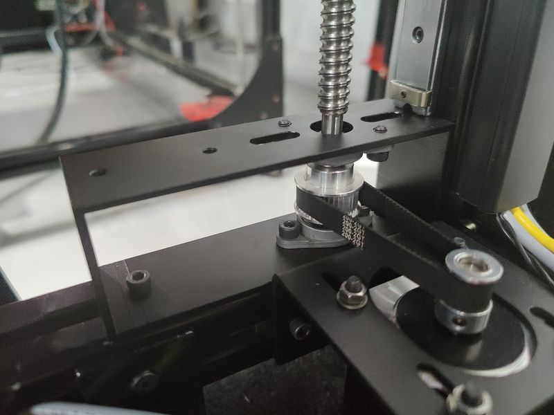 Gros plan sur le mécanisme de l'axe Z de l'imprimante 3D Modix BIG-180X, avec vis à billes et système d'entraînement du plateau, illustrant la stabilité mécanique et le positionnement vertical précis.